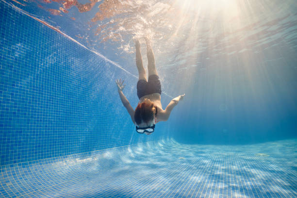 istock Boy diving in clear swimming pool 1601040538