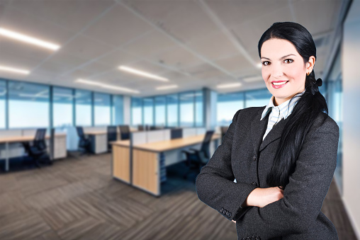 Confident businesswoman with crossed arms in office.