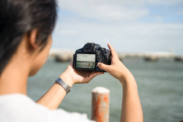 istock A boy taking pictures at the seaside with a camera 1601047159