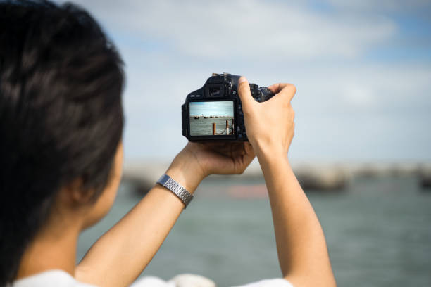istock A boy taking pictures at the seaside with a camera 1601047161