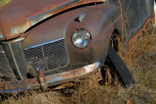A down and out old rusty car from the 1940s.