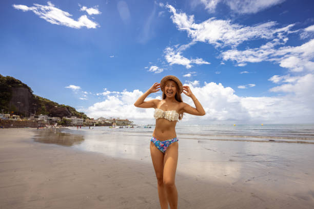 Happy woman in bikini standing on summer beach