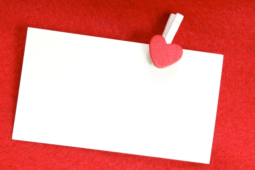 A clip with a heart holding a white sheet of paper