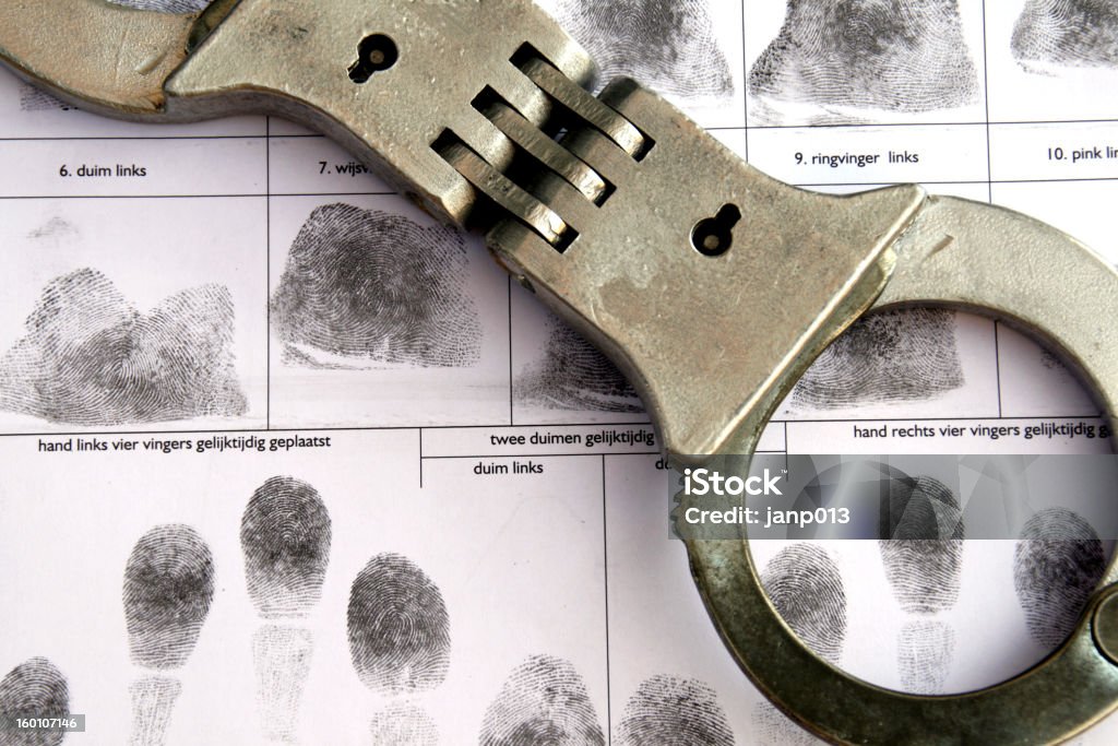 fingerprint handcuffs with fingerprints on  background. Handcuffs Stock Photo