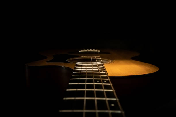 istock Acoustic Guitar on a Black Background 1601075422
