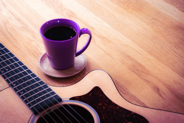istock An Acoustic Guitar and a Purple Coffee Cup on the Table 1601075862