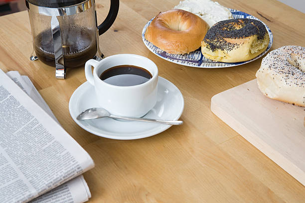 Coffee with news paper and bagels stock photo