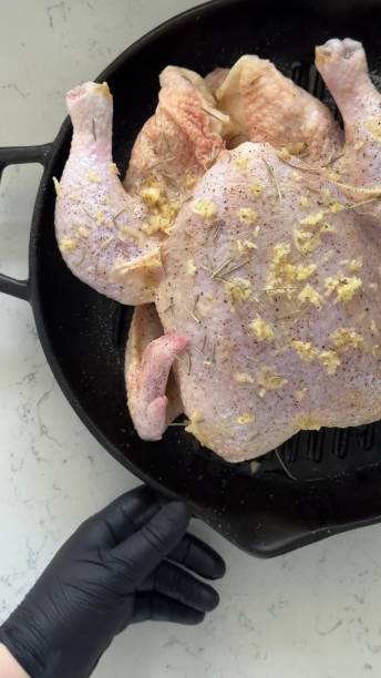 istock Whole raw free-range chicken in a black kitchen grill pan. Gray background. View from above 1601082036