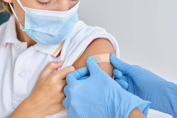 istock Crop doctor applying patch on shoulder of patient in mask 1601084272