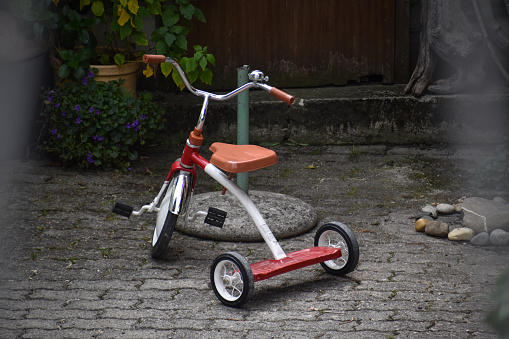 An orange three wheeled kid's bike