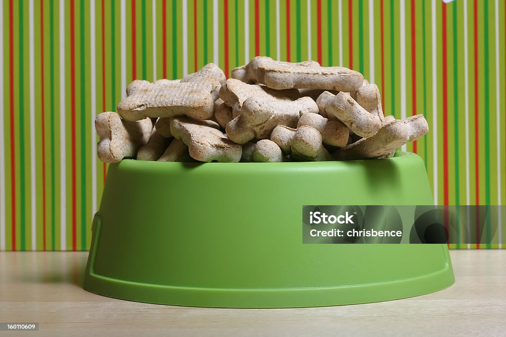 Merry Christmas, Doggie. Dog treats over-flowing in green dog bowl. Dog Bowl Stock Photo