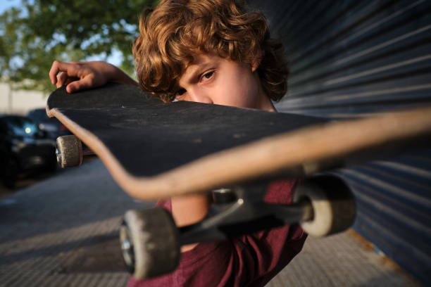 istock Serious little skater inspecting skateboard 1601113300