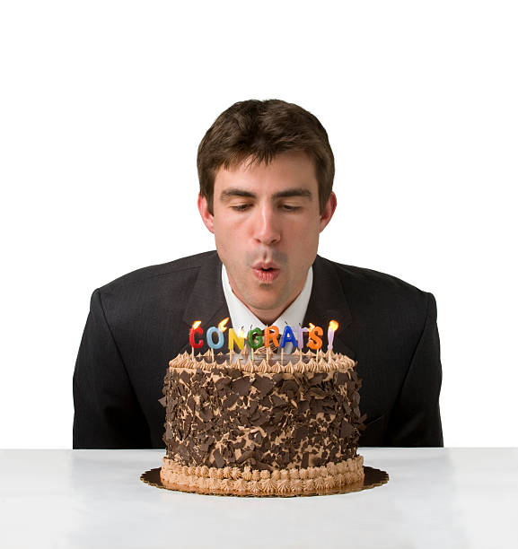 istock Man in suit blows out candles 160111405