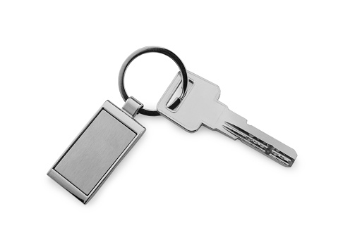 Key with metallic keychain isolated on white, top view