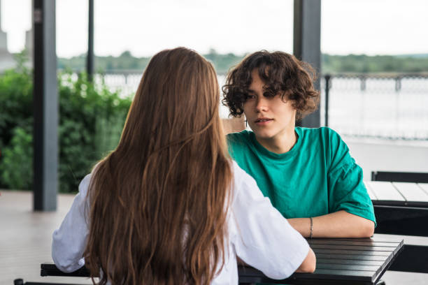 young couple talking while sitting at a street food table