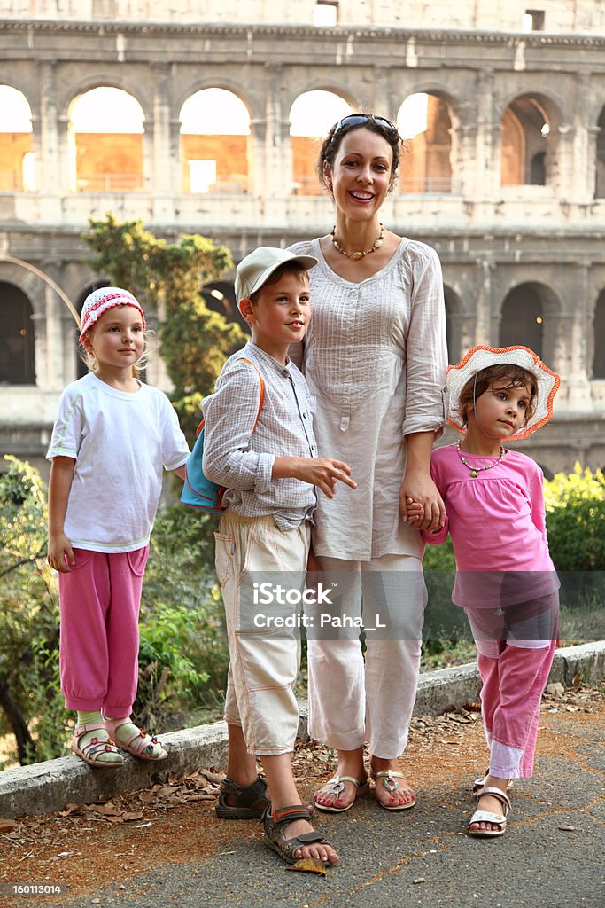 Mother, little son and two daughters are near Colosseum Young mother, little son and two daughters are near Colosseum in Rome, focus on boy Adult Stock Photo