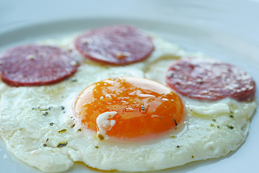fried egg mixed with sausage on a plate .