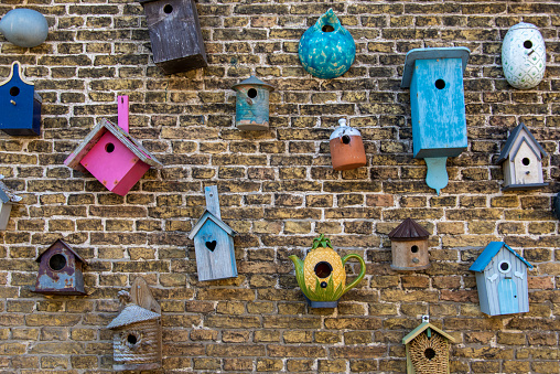 Collection of birdhouses against a brick wall.