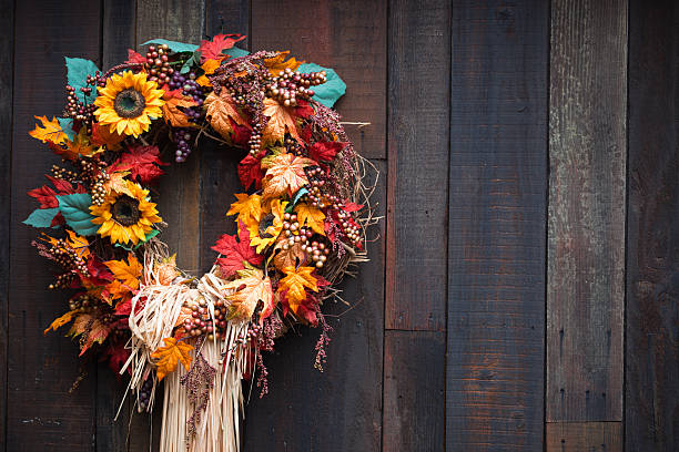 Autumnal wreath with sunflowers and leaves on wooden surface stock photo