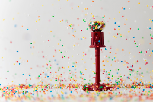 Miniature gumball machine with 100s and 1000s raining down to give the effect of it raining bubblegum. Shallow depth of field with the focus on the gumball machine. Many variants to choose from.