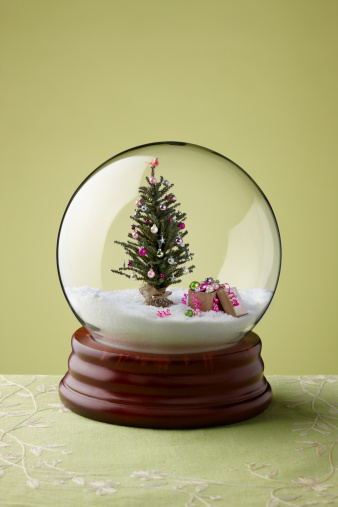 Delightfully decorated Christmas Tree inside of a snow globe.