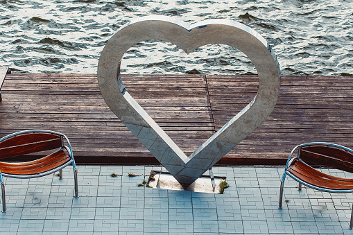 Sculpture in form of a heart made of metal on the sea pier