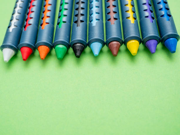 pastelli multicolori per disegnare su uno sfondo verde. - pastel crayon foto e immagini stock