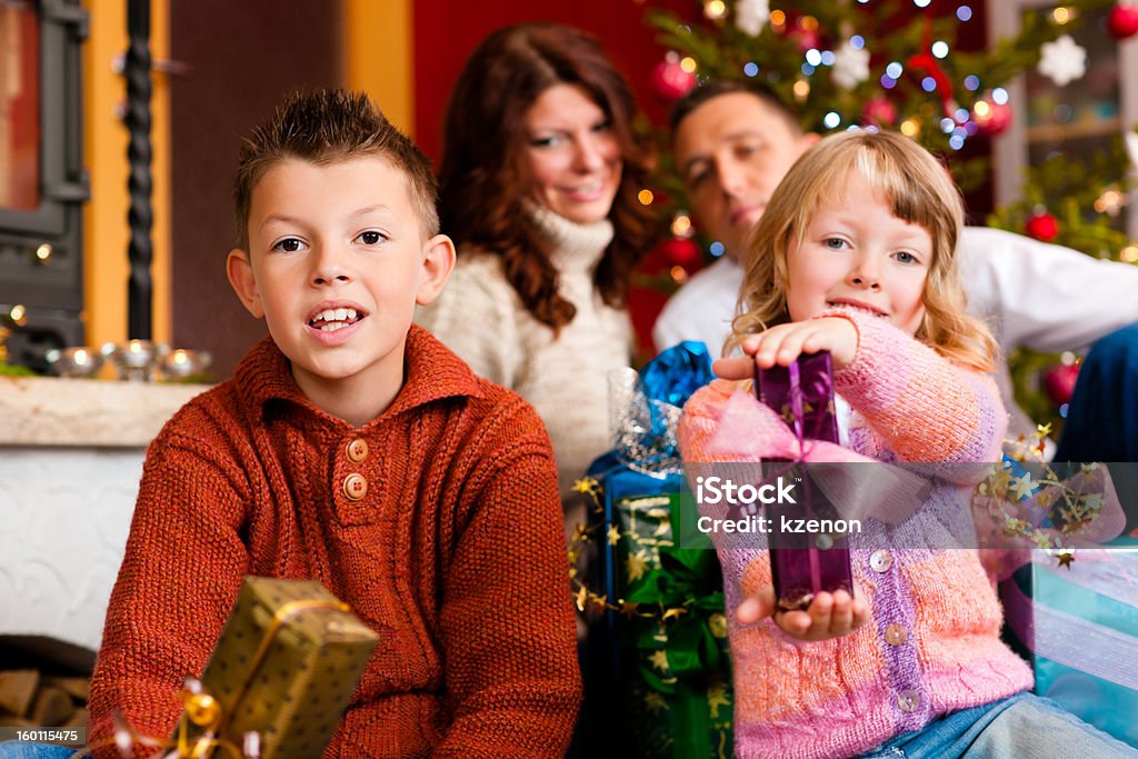Christmas - family with gifts on Xmas Eve Christmas - happy family (parents with son and daughter) with gifts on Xmas Eve Adult Stock Photo