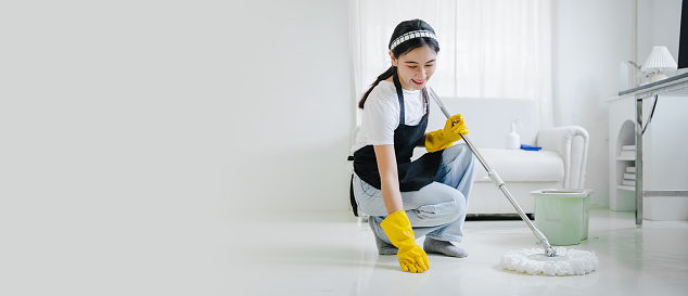 young woman mopping the floor cleaning at home smiling cheerful
cleaning staff cleaning concept