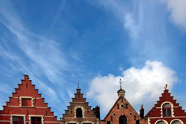 Charming, ornate roofs against blue sky and clouds