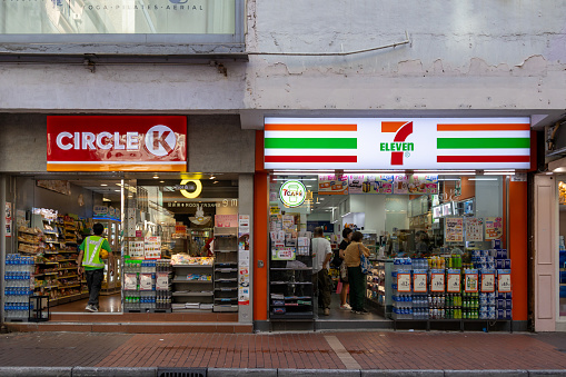Hong Kong - August 8, 2023 :  Customers at Circle K and 7-Eleven convenience stores in Hong Kong. Both are international chain of convenience stores.