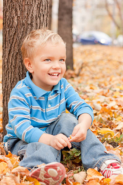 istock Cheerful boy sitting on yellow foliage . 160118426
