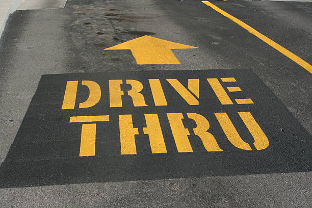 DRIVE THRU with arrow painted on a driveway stock photo