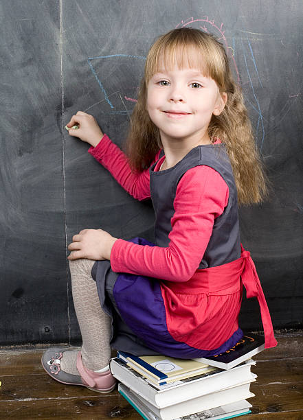 istock little cute girl writing on the blackboard 160118583