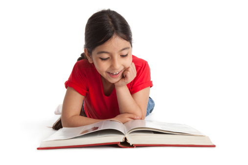 Eight year old girl reading a book on white background