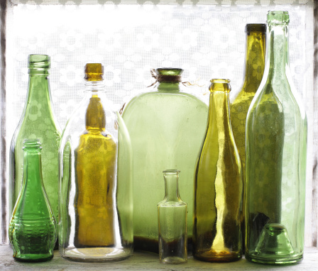 Old green glass bottles on windowsill