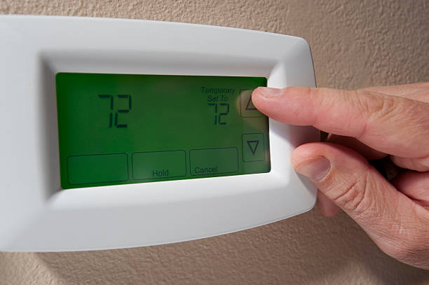 Changing the temperature on a digital thermostat stock photo