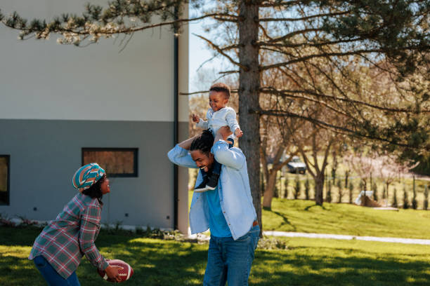 istock Mom and dad playing with son outside. 1601228180