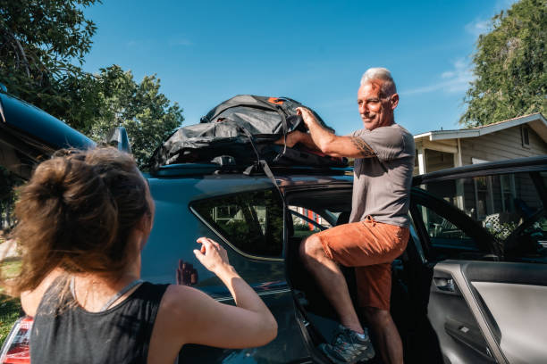 istock Mature Man Helping Daughter Pack Luggage Above Car 1601246239