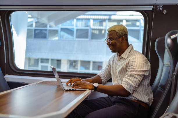 istock African American businessman using laptop in train 1601253244