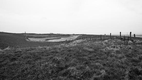 Black and white image on an overcast day at the Wadden Island of Texel, with the lighthouse in the background.