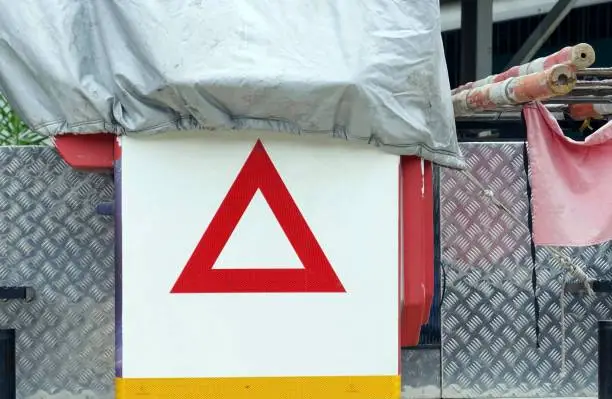 A trunk cranes minicar for wiring communication lines with label warning a weight and a wooden stairs tie a red flag to warn.