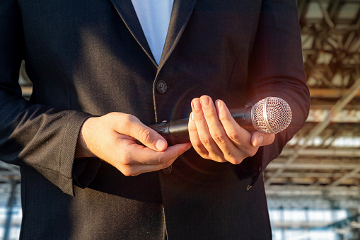 Man holding a microphone. The concept of speaking at a business forum and large venues.