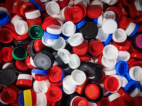 Macro of a large group of red, white, black and blue plastic bottle caps texture background ready to recycled.