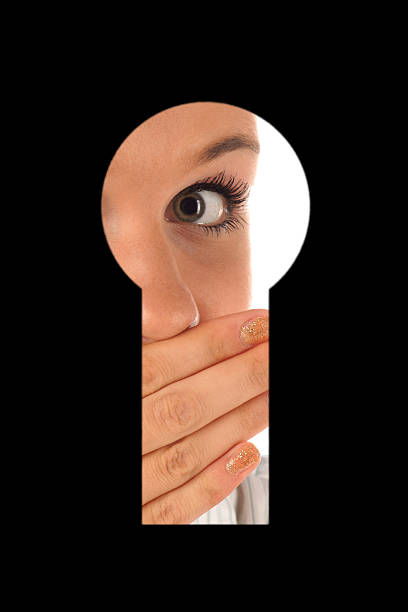 Looking in keyhole KI Portrait of surprised girl which looking in keyhole woman spying through a keyhole stock pictures, royalty-free photos & images