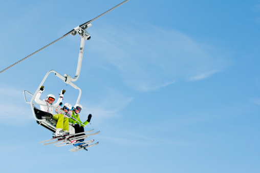 Trio of skiers riding on a ski lift