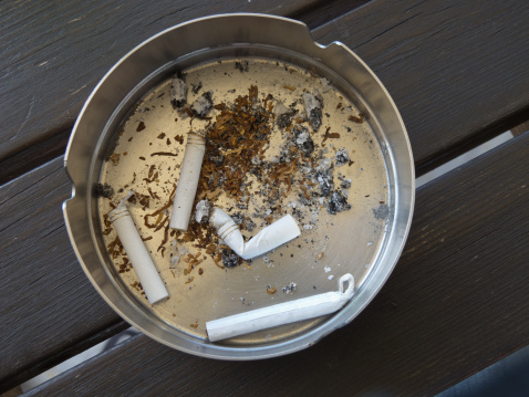 silver ashtray with cigarette butts
