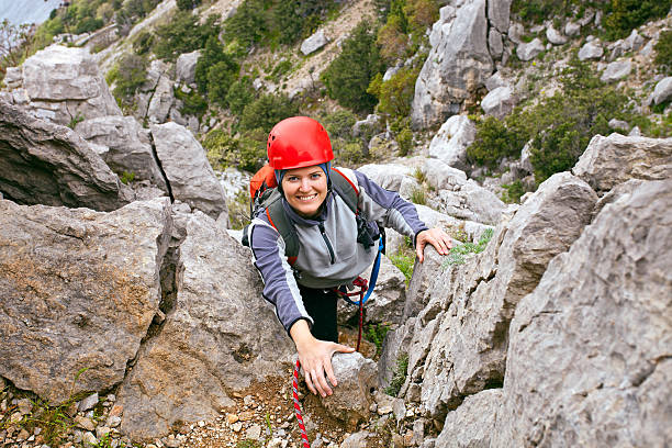 joyeux femelle grimpeur s'élevant à rock - climbing mountain climbing rock climbing women photos et images de collection