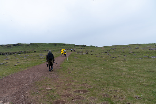 Latrabjarg, Iceland - July 3, 2023: Hikers start on the trail up to the cliffs of Latrabjarg to view birds and practice photography