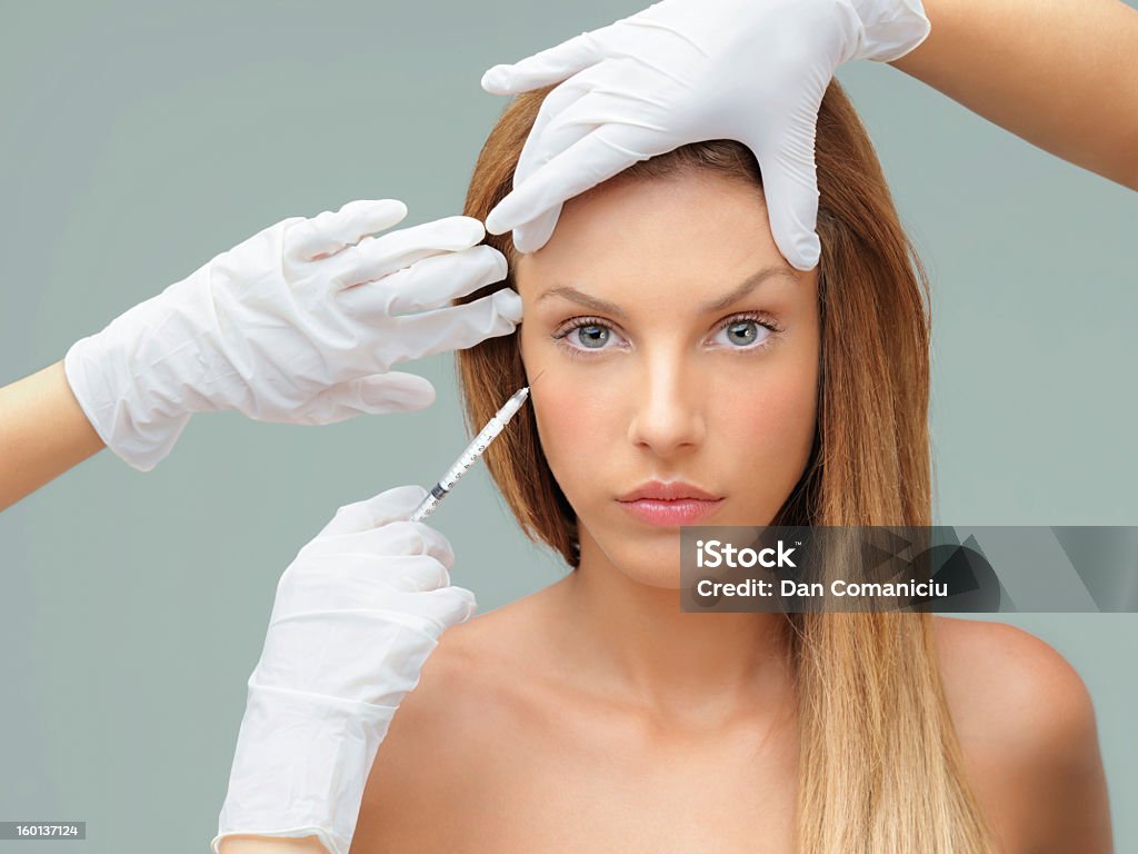 Jeune femme avec le Docteur mains injecter de botox - Photo de Adulte libre de droits